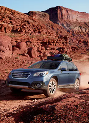 Subaru Outback in Blue driving in a warm environment.